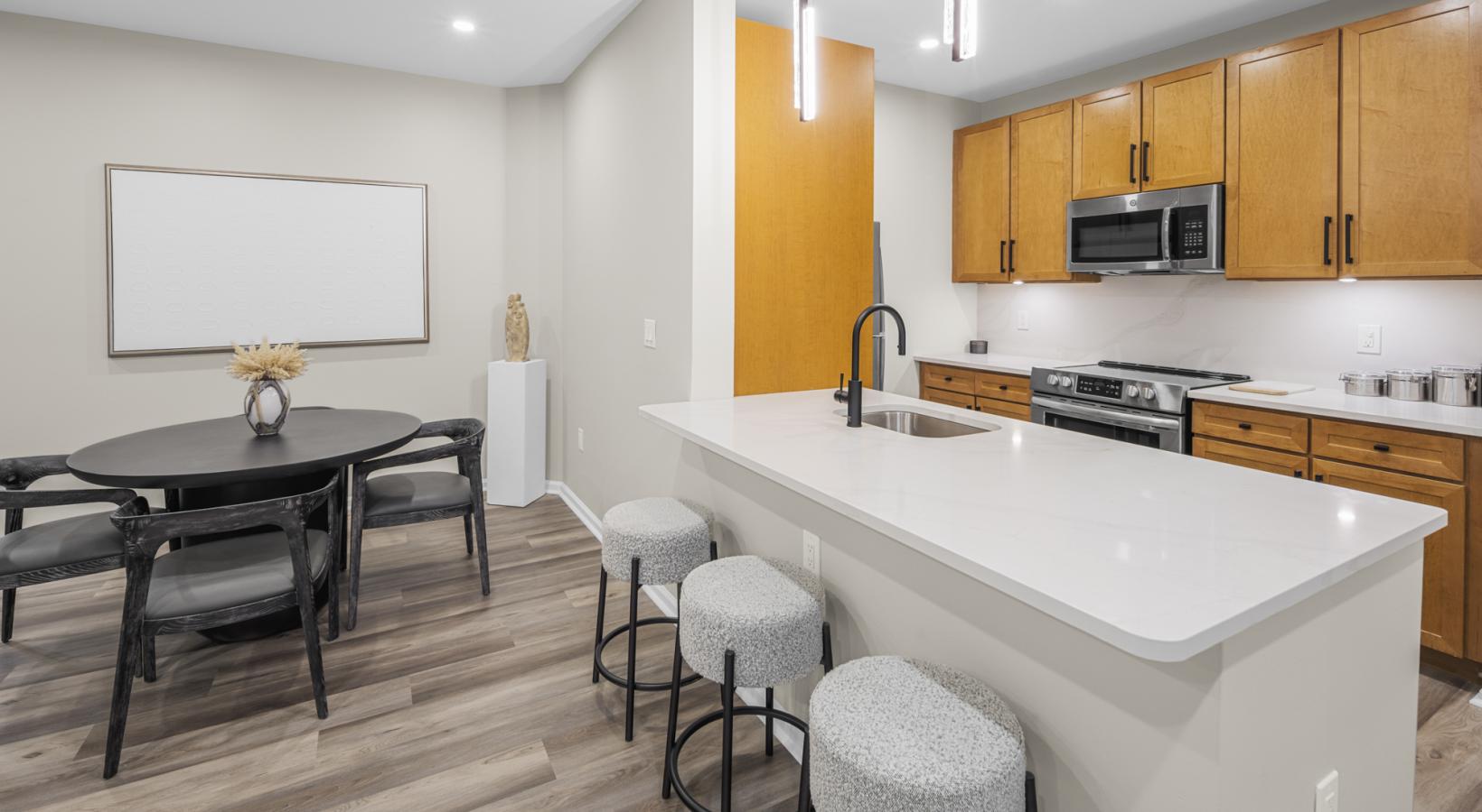 a kitchen with an island with seating and a table and chairs