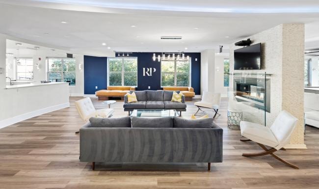 Take advantage of all Renaissance Plaza Square has to offer a lounge with a large couch chairs fireplace and tv