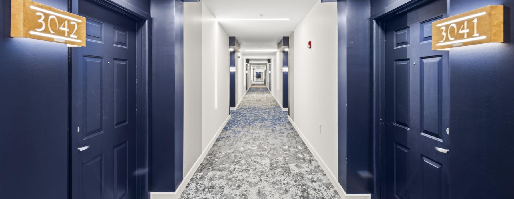 a long hallway with blue doorways